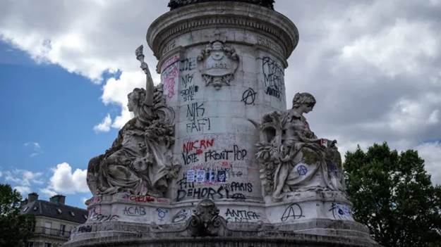 A statue with graffiti on it

Description automatically generated
